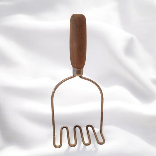 antique potato masher with a wooden handle 